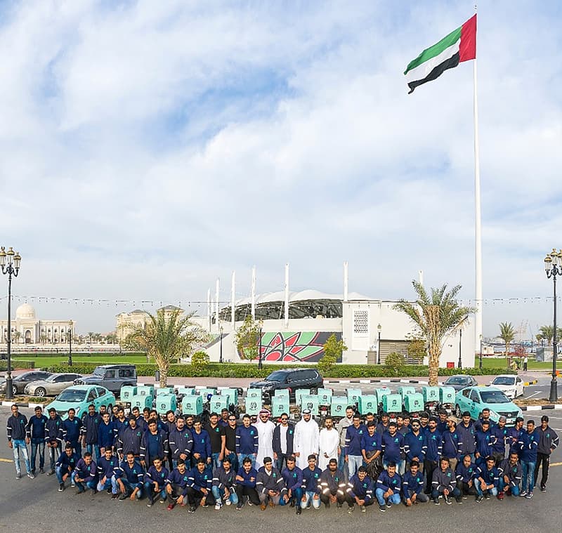 The Tawseel rider team lined up with their motorbikes under the UAE flag